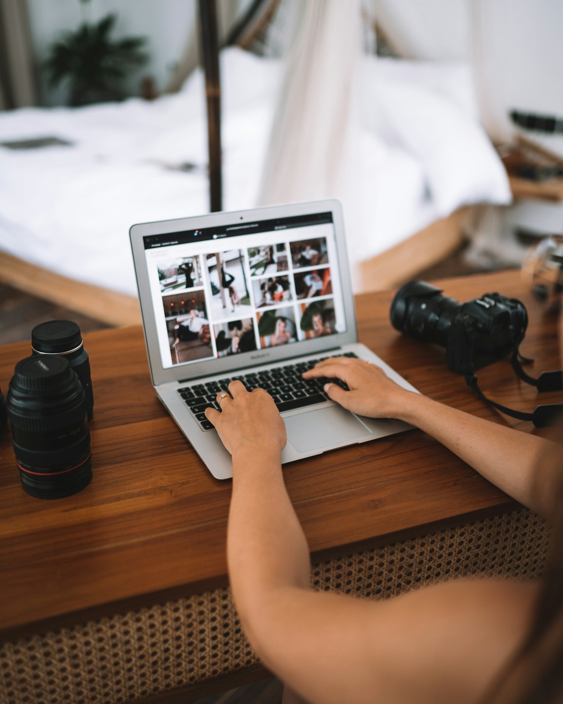 Photographer reviewing photos on a laptop at a desk.