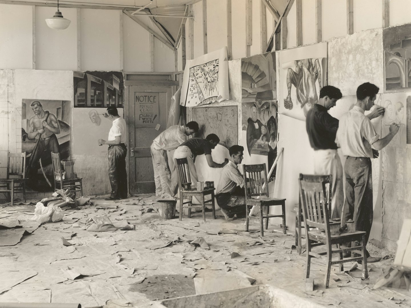 Creators work on studio and design projects surrounded by scattered supplies.