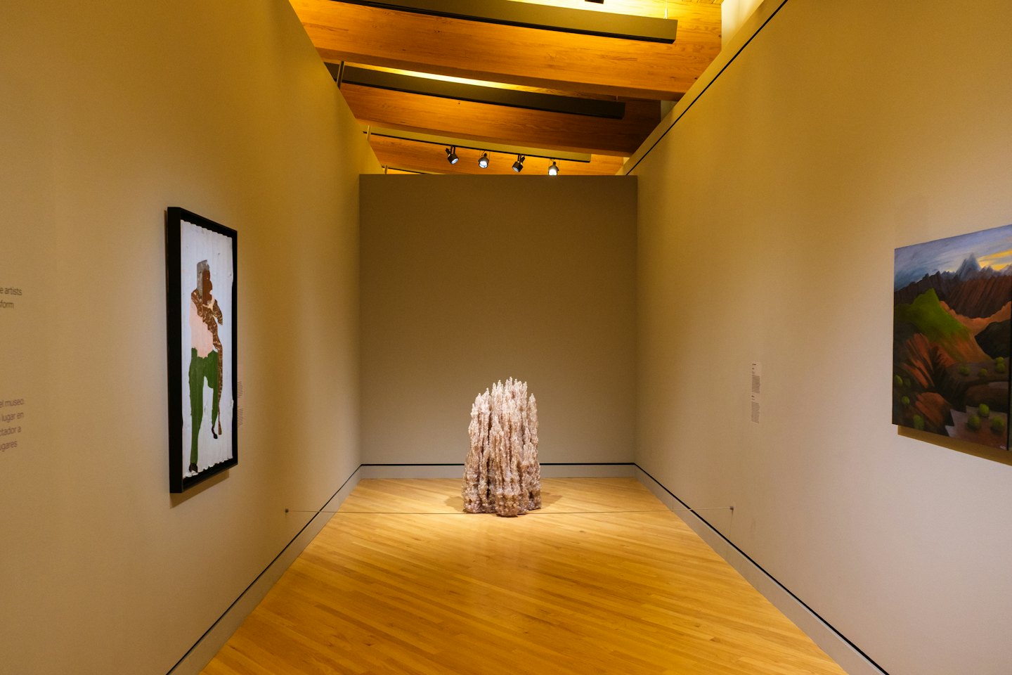 Art gallery corridor with abstract and landscape paintings.